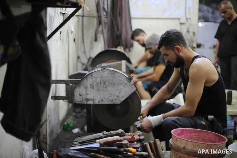 Palestinian ean sharpen knives at their workshop in Gaza city on August 29, 2017. The knives use to slaughter cattle and sheep for the Muslim holiday of Eid al-Adha or the Feast of Sacrifice, which marks the end of the a...