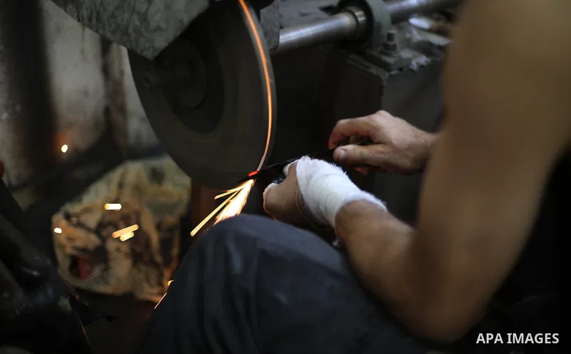 A Palestinian man sharpen knives at his workshop in Gaza city on August 29, 2017. The knives use to slaughter cattle and sheep for the Muslim holiday of Eid al-Adha or the Feast of Sacrifice, which marks the end of the a...