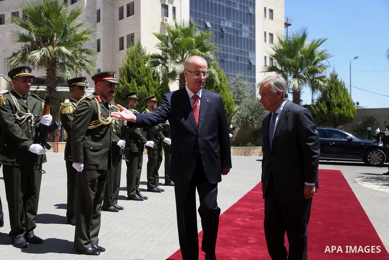 Palestinian Prime Minister Rami Hamdallah and United Nations Secretary-General Antonio Guterres review an honour guard during a reception ceremony in the West Bank city of Ramallah August 29, 2017. Photo by Shadi Hatem