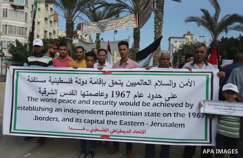 Palestinians hold placards upon arrival of United Nations Secretary General Antonio Guterres in Beit Lahia in the northern Gaza Strip on August 30, 2017. Photo by Mohammed Asad