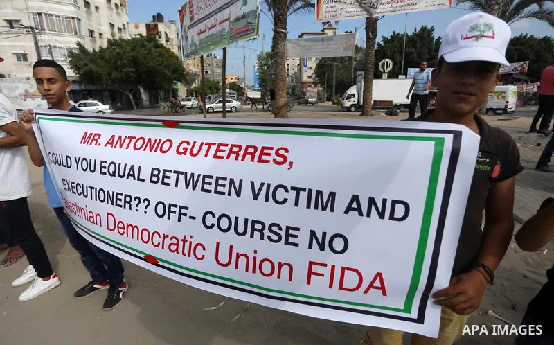 Palestinians hold placards upon arrival of United Nations Secretary General Antonio Guterres in Beit Lahia in the northern Gaza Strip on August 30, 2017. Photo by Mohammed Asad