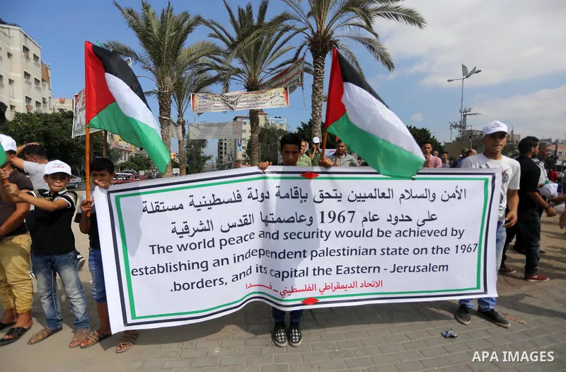 Palestinians hold placards upon arrival of United Nations Secretary General Antonio Guterres in Beit Lahia in the northern Gaza Strip on August 30, 2017. Photo by Mohammed Asad