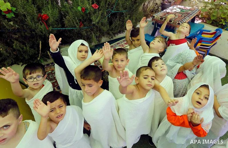 Palestinian children gather around a makeshift cube representing the holy Kaaba, in the West bank city of Hebnron, on August 30, 2017, as part of training children how to perform Hajj pilgrimage. Muslims from around the...