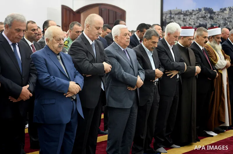 Palestinian President Mahmoud Abbas and his Prime Minister Rami Hamdallah perform Eid al-Adha prayers, in the West Bank city of Ramallah on September 1, 2017. Photo by Osama Falah