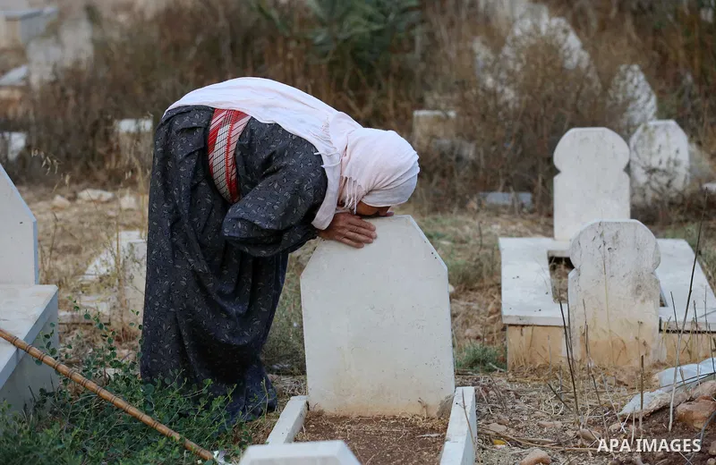 A Palestinian woman visits the grave of her relative at a cemetery on the first day of Eid al-Adha, or feast of the sacrifice, in the West Bank village of Lubban Ash-Sharqiya near Nablus, on September 1, 2017. Muslims ar...