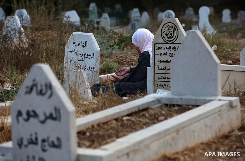 A Palestinian woman visits the grave of her relative at a cemetery on the first day of Eid al-Adha, or feast of the sacrifice, in the West Bank village of Lubban Ash-Sharqiya near Nablus, on September 1, 2017. Muslims ar...