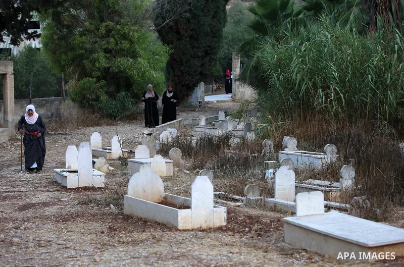 Palestinian women visit graves of their relatives at a cemetery on the first day of Eid al-Adha, or feast of the sacrifice, in the West Bank village of Lubban Ash-Sharqiya near Nablus, on September 1, 2017. Muslims aroun...