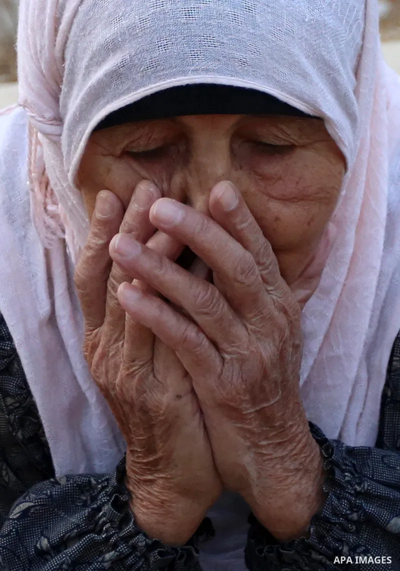 A Palestinian woman visits the grave of her relative at a cemetery on the first day of Eid al-Adha, or feast of the sacrifice, in the West Bank village of Lubban Ash-Sharqiya near Nablus, on September 1, 2017. Muslims ar...