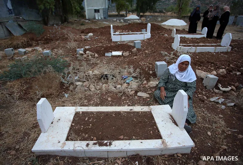 A Palestinian woman visits the grave of her relative at a cemetery on the first day of Eid al-Adha, or feast of the sacrifice, in the West Bank village of Lubban Ash-Sharqiya near Nablus, on September 1, 2017. Muslims ar...