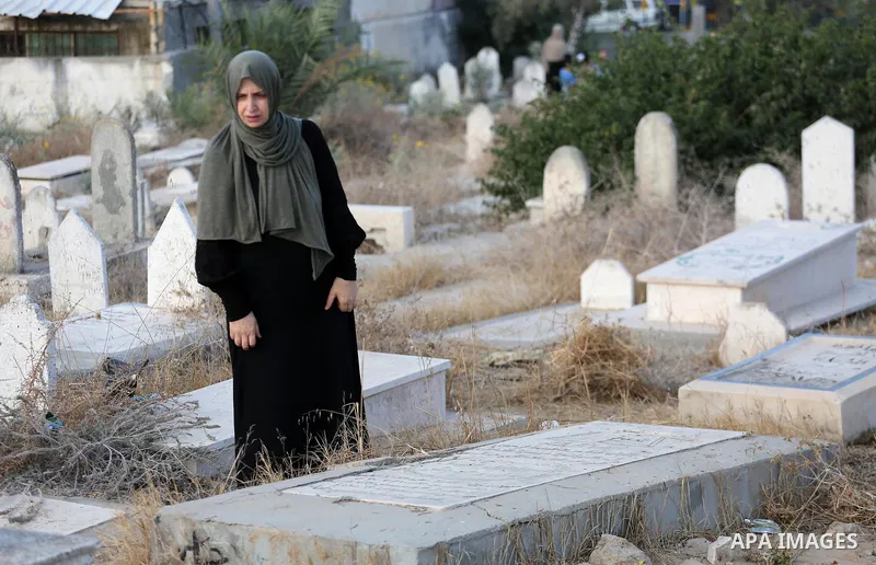 A Palestinian woman visits the grave of her relative at a cemetery on the first day of Eid al-Adha, or feast of the sacrifice, in Gaza city, on September 1, 2017. Muslims around the world are celebrating Eid al-Adha, the...