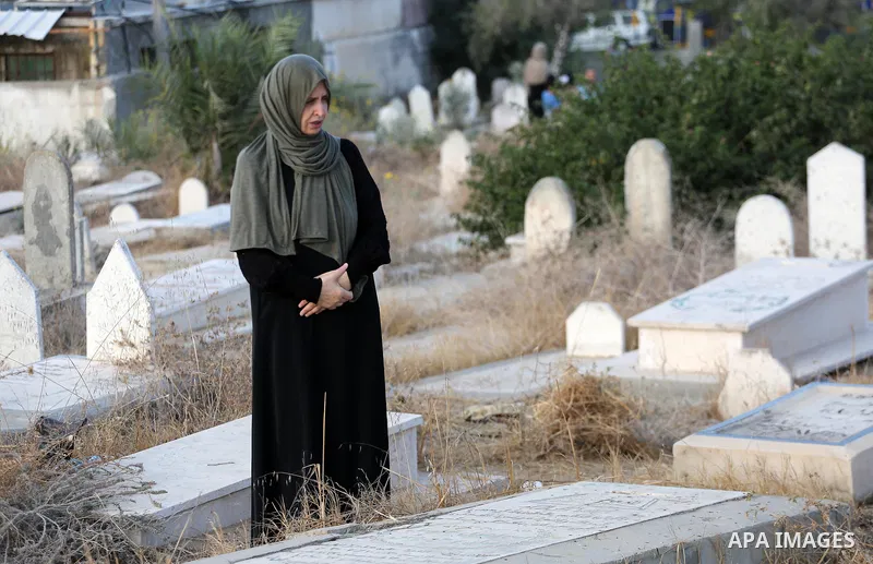 A Palestinian woman visits the grave of her relative at a cemetery on the first day of Eid al-Adha, or feast of the sacrifice, in Gaza city, on September 1, 2017. Muslims around the world are celebrating Eid al-Adha, the...