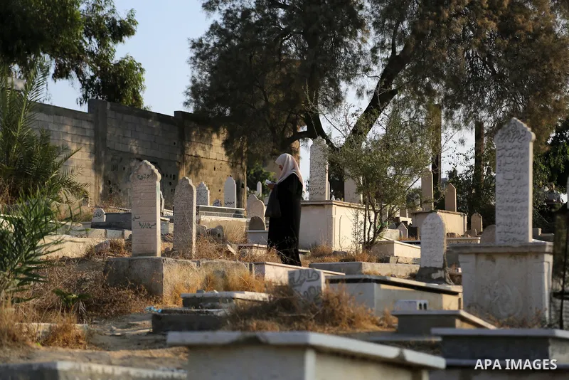 A Palestinian woman visits the grave of her relative at a cemetery on the first day of Eid al-Adha, or feast of the sacrifice, in Gaza city, on September 1, 2017. Muslims around the world are celebrating Eid al-Adha, the...