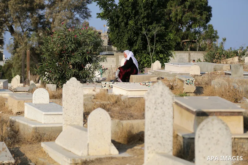 A Palestinian woman visits the grave of her relative at a cemetery on the first day of Eid al-Adha, or feast of the sacrifice, in Gaza city, on September 1, 2017. Muslims around the world are celebrating Eid al-Adha, the...