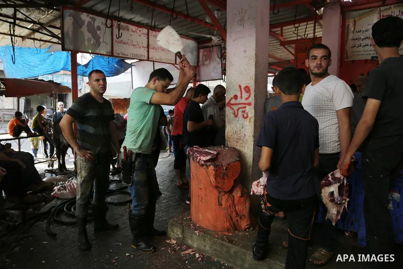 Palestinians cut up pieces of meat from a slaughtered bull as part of the commemoration for the first day of Eid al-Adha or feast of the sacrifice, in Gaza city on September 1, 2017. Muslims around the world are celebrat...