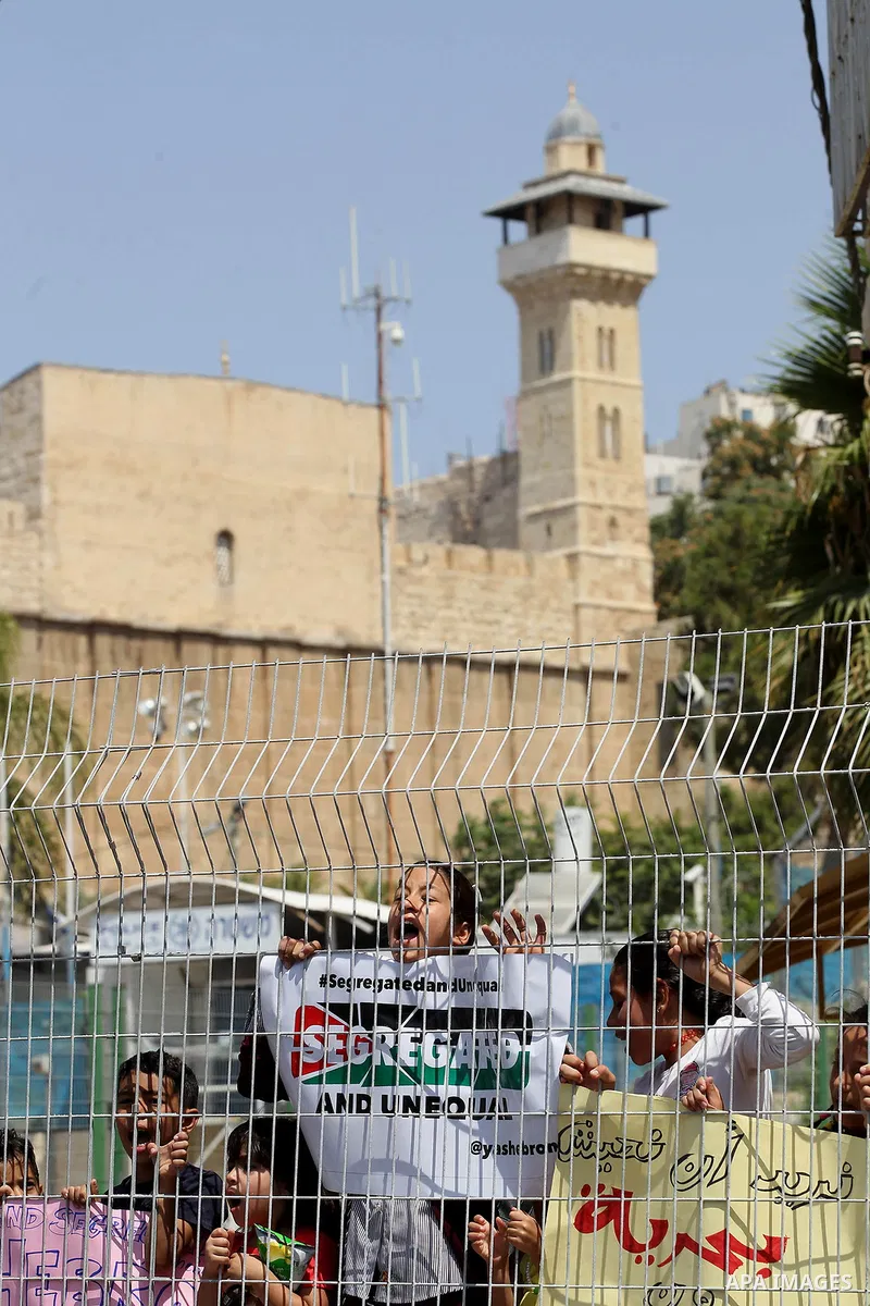 Palestinians hold placards during a demonstration organised by young Palestinians in Hebron on September 3, 2017, against a recent decision by Israel to boost the powers of the settlers in the occupied West Bank city. Is...