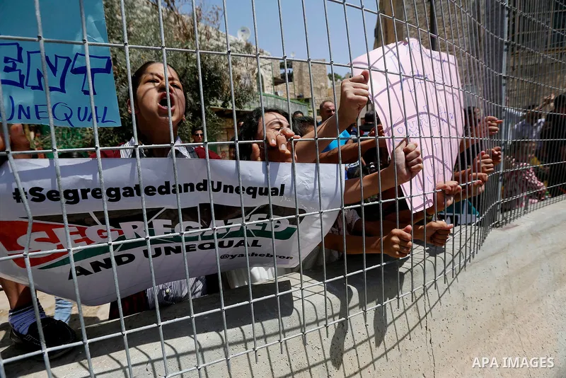 Palestinians hold placards during a demonstration organised by young Palestinians in Hebron on September 3, 2017, against a recent decision by Israel to boost the powers of the settlers in the occupied West Bank city. Is...