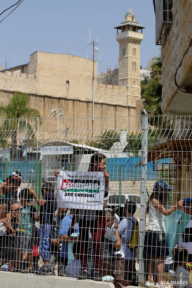 Palestinians hold placards during a demonstration organised by young Palestinians in Hebron on September 3, 2017, against a recent decision by Israel to boost the powers of the settlers in the occupied West Bank city. Is...