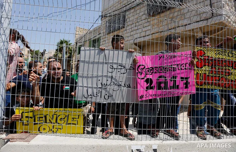 Palestinians hold placards during a demonstration organised by young Palestinians in Hebron on September 3, 2017, against a recent decision by Israel to boost the powers of the settlers in the occupied West Bank city. Is...