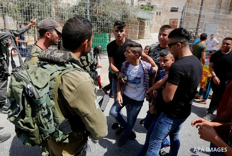 Palestinian children argue with Israeli border policemen during a demonstration organised by young Palestinians in Hebron on September 3, 2017, against a recent decision by Israel to boost the powers of the settlers in t...