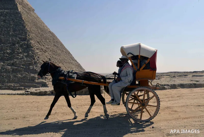 Egyptians ride horse carts on the third day of Eid al-Adha or the feast of sacrifice, in front of the Giza pyramids, in Cairo on September 03, 2017. Muslims around the world are celebrating Eid al-Adha, the "Feast of Sac...