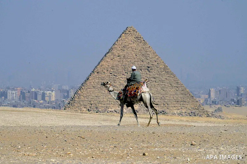 An Egyptian man rides a camel on the third day of Eid al-Adha or the feast of sacrifice, in front of the Giza pyramids, in Cairo on September 03, 2017. Muslims around the world are celebrating Eid al-Adha, the "Feast of...