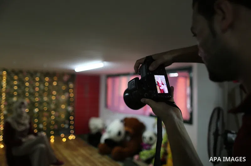 A Palestinian photographer, Ibrahim Faraj takes pictures during a photoshoot on Eid al-Adha or the feast of sacrifice, in Gaza city, on September 4, 2017. Photo by Yasser Qudih