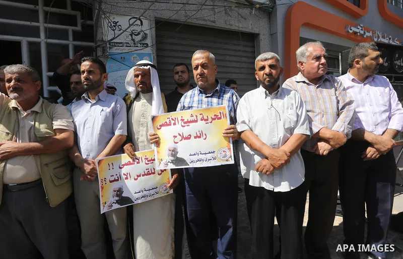 Palestinians hold banners during a protest to show solidarity with Leader of the northern Islamic Movement Sheikh Raed Salah who is held in Israeli jails in Gaza city, on Sept. 6, 2017. Photo by Mohammed Asad