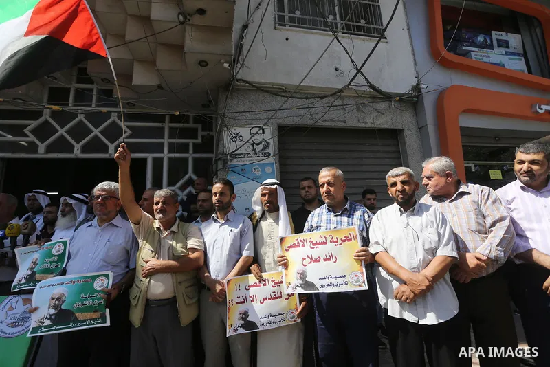 Palestinians hold banners during a protest to show solidarity with Leader of the northern Islamic Movement Sheikh Raed Salah who is held in Israeli jails in Gaza city, on Sept. 6, 2017. Photo by Mohammed Asad