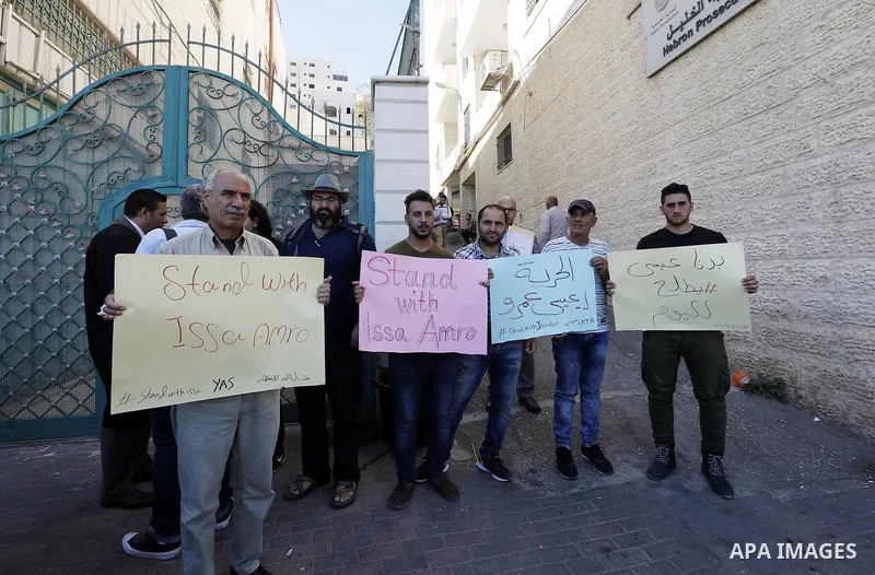 Supporters of Issa Amro, a prominent Palestinian activist and founder of Youth Against Settlements, protest outside the court in the West Bank town of Hebron on September 7, 2017, after he was detained for criticising th...