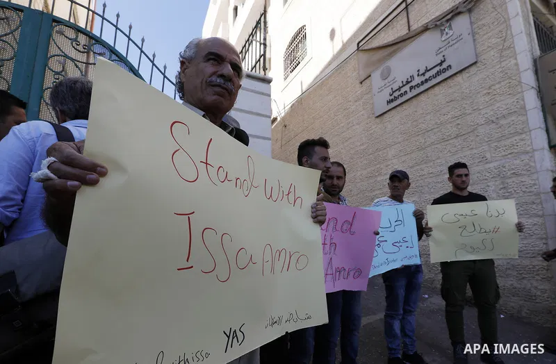 Supporters of Issa Amro, a prominent Palestinian activist and founder of Youth Against Settlements, protest outside the court in the West Bank town of Hebron on September 7, 2017, after he was detained for criticising th...