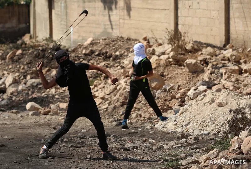 A Palestinian protester hurls stones towards Israeli troops during clashes near the Jewish settlement of Qadomem, in the West Bank village of Kofr Qadom near Nablus September 8, 2017. Photo by Ayman Ameen
