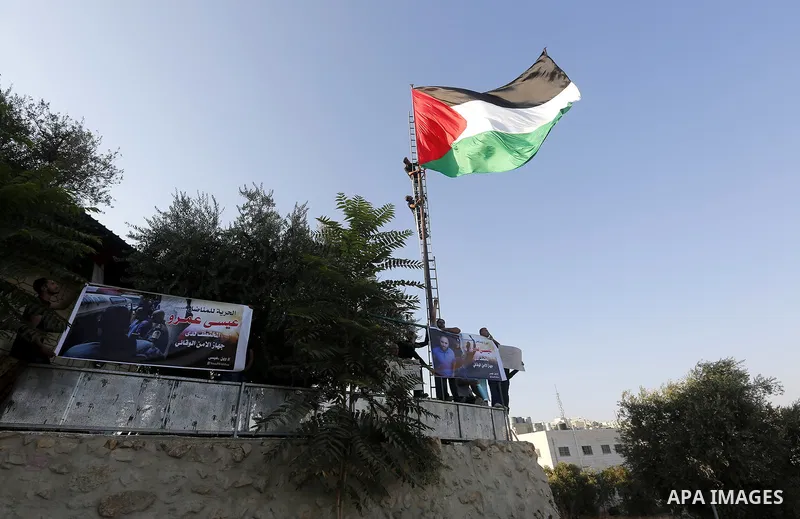 Palestinians hang a Palestine flag during a protest in Tal Rumaida in the West Bank city of Hebron, September 8, 2017. Reports state activists from 'Youth against settlements' group gathered to protest against the Israel...