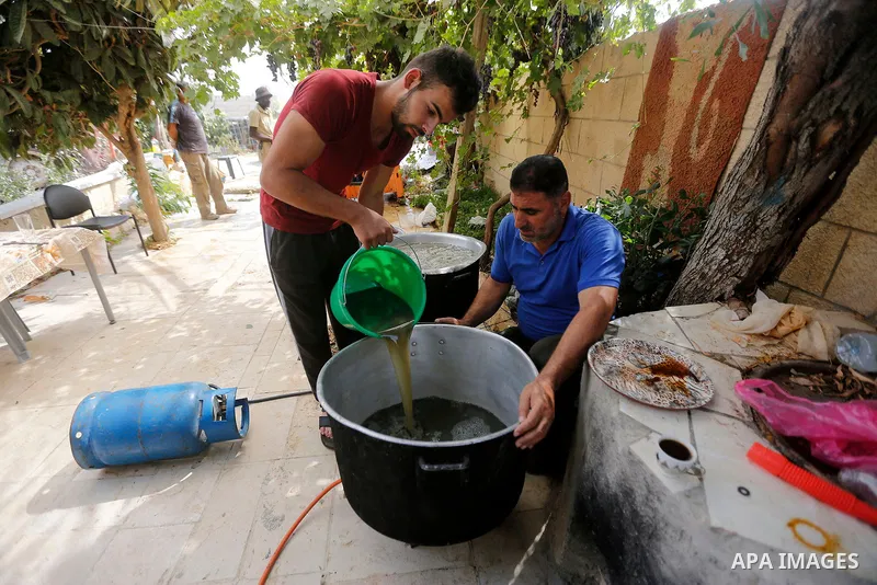 A Palestinian farmer prepares the grape juice at his field near the West Bank city of Hebron, Sept. 14, 2017. Hebron is famous for its quality grape production and its lush vineyards. Photo by Wisam Hashlamoun