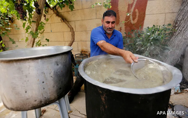 A Palestinian farmer prepares the grape juice at his field near the West Bank city of Hebron, Sept. 14, 2017. Hebron is famous for its quality grape production and its lush vineyards. Photo by Wisam Hashlamoun