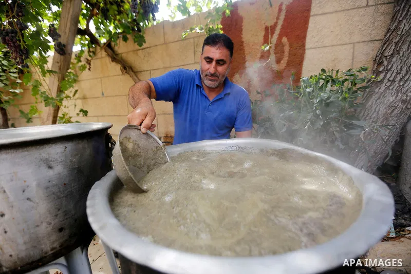 A Palestinian farmer prepares the grape juice at his field near the West Bank city of Hebron, Sept. 14, 2017. Hebron is famous for its quality grape production and its lush vineyards. Photo by Wisam Hashlamoun