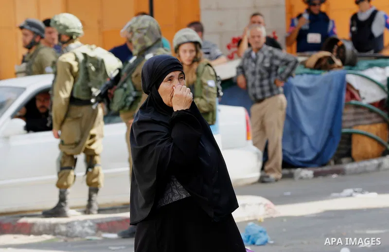 A Palestinian woman crosses the road during a demonstration in the West Bank city of Hebron on September 15, 2017. Israel has given Jewish settlement enclaves in the occupied West Bank city of Hebron the authority to man...