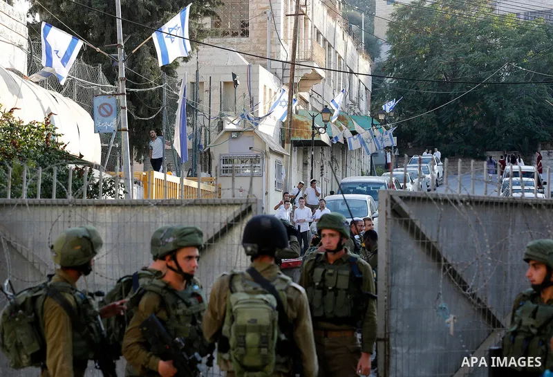 Israeli soldiers stand guard as Jewish settlers tour of the streets in the Old City of the West Bank city of Hebron on September 16, 2017. Photo by Wisam Hashlamoun