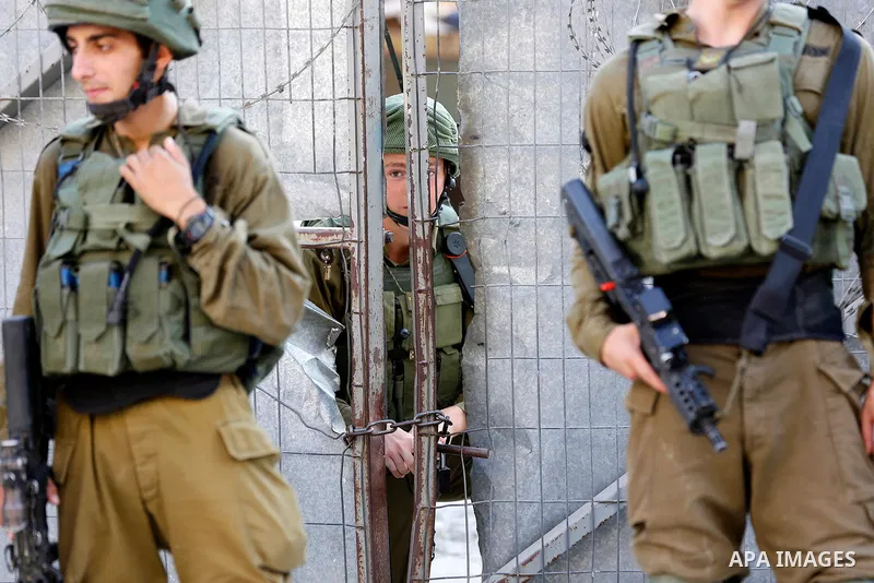 Israeli soldiers stand guard as Jewish settlers tour of the streets in the Old City of the West Bank city of Hebron on September 16, 2017. Photo by Wisam Hashlamoun