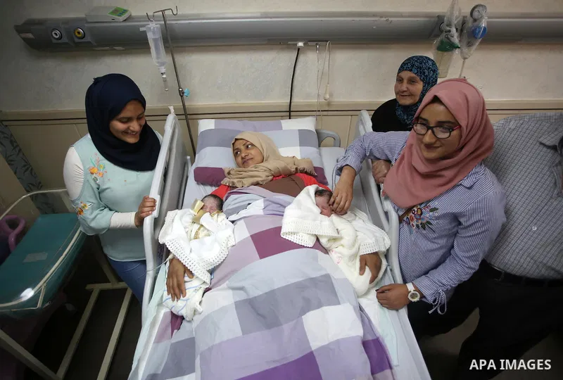 Suha, 33, the wife of Palestinian prisoner Qasim al-Akeleek, 34, lies on a bed next to her twins Aboud and Hagar who were conceived with sperm from her husband smuggled out of an Israeli prison at Arab Specialist Hospita...