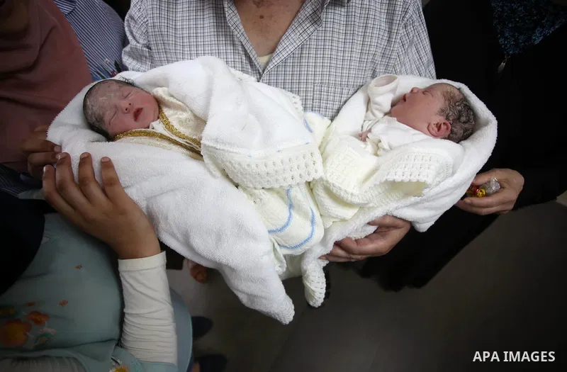 The father of Palestinian prisoner Qasim al-Akeleek, 34, holds his son's twins Aboud and Hagar who were conceived with sperm from his son Qasim smuggled out of an Israeli prison at Arab Specialist Hospital in the West Ba...