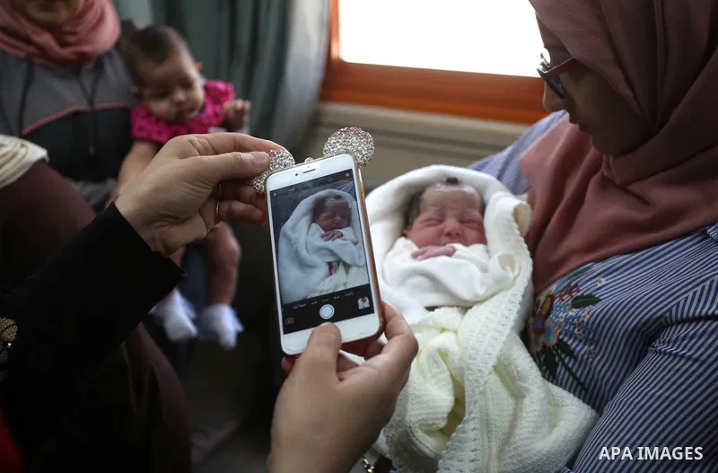 The daughter of Palestinian prisoner Qasim al-Akeleek, 34, holds one of twins who were conceived with sperm from her father smuggled out of an Israeli prison at Arab Specialist Hospital in the West Bank city of Nablus on...