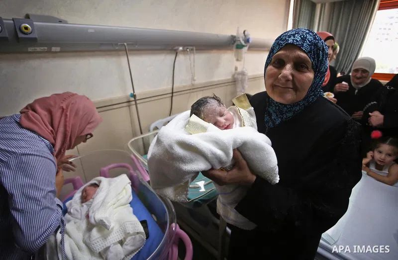 The mother of Palestinian prisoner Qasim al-Akeleek, 34, holds one of her son's twins who were conceived with sperm from her son Qasim smuggled out of an Israeli prison at Arab Specialist Hospital in the West Bank city o...