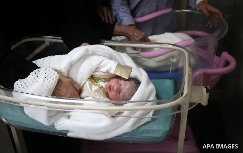 Relatives gather around the twins of Palestinian prisoner Qasim al-Akeleek, 34, who were conceived with sperm from him smuggled out of an Israeli prison at Arab Specialist Hospital in the West Bank city of Nablus on Sept...