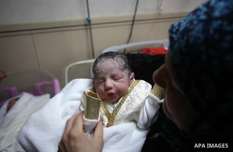The mother of Palestinian prisoner Qasim al-Akeleek, 34, holds one of her son's twins who were conceived with sperm from her son Qasim smuggled out of an Israeli prison at Arab Specialist Hospital in the West Bank city o...