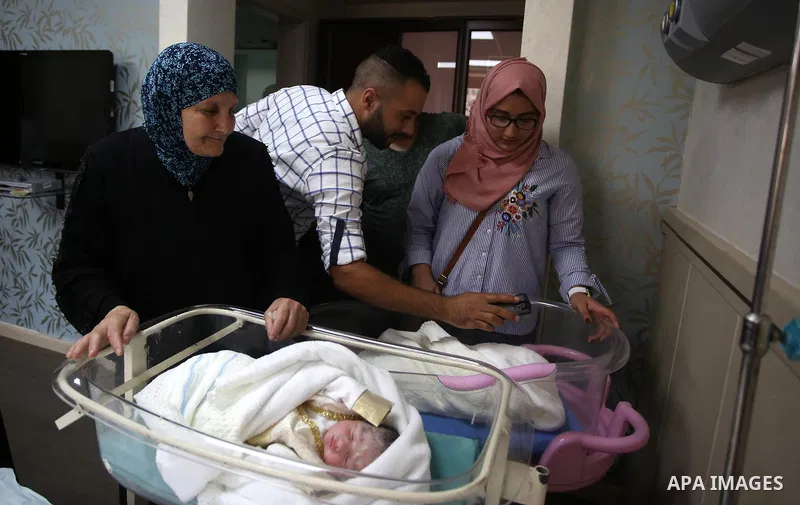 Relatives gather around the twins of Palestinian prisoner Qasim al-Akeleek, 34, who were conceived with sperm from him smuggled out of an Israeli prison at Arab Specialist Hospital in the West Bank city of Nablus on Sept...