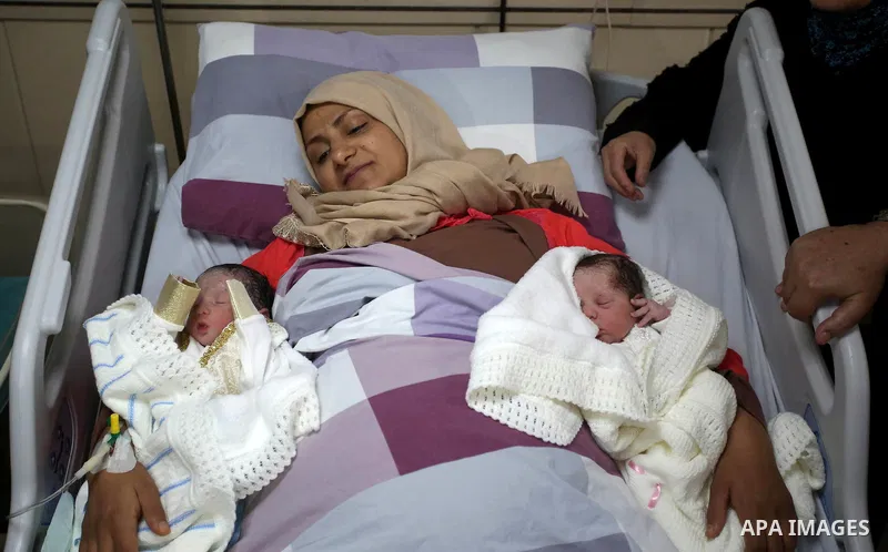 Suha, 33, the wife of Palestinian prisoner Qasim al-Akeleek, 34, lies on a bed next to her twins Aboud and Hagar who were conceived with sperm from her husband smuggled out of an Israeli prison at Arab Specialist Hospita...