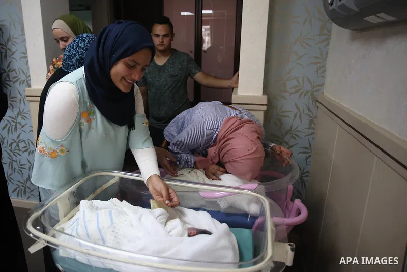 Relatives gather around the twins of Palestinian prisoner Qasim al-Akeleek, 34, who were conceived with sperm from him smuggled out of an Israeli prison at Arab Specialist Hospital in the West Bank city of Nablus on Sept...
