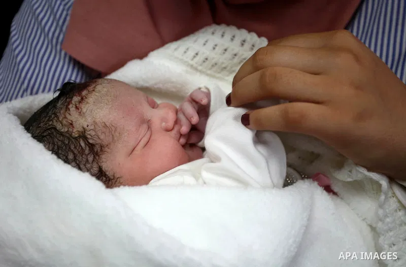 The daughter of Palestinian prisoner Qasim al-Akeleek, 34, holds one of twins who were conceived with sperm from her father smuggled out of an Israeli prison at Arab Specialist Hospital in the West Bank city of Nablus on...