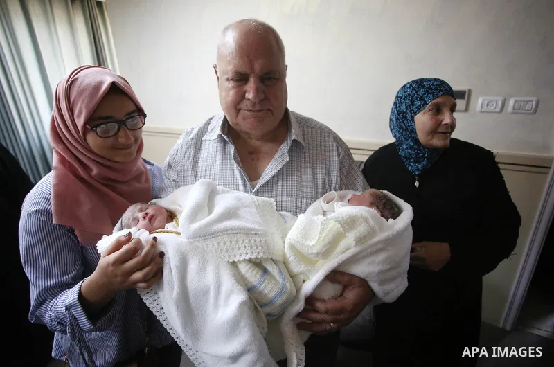 The father of Palestinian prisoner Qasim al-Akeleek, 34, holds his son's twins Aboud and Hagar who were conceived with sperm from his son Qasim smuggled out of an Israeli prison at Arab Specialist Hospital in the West Ba...