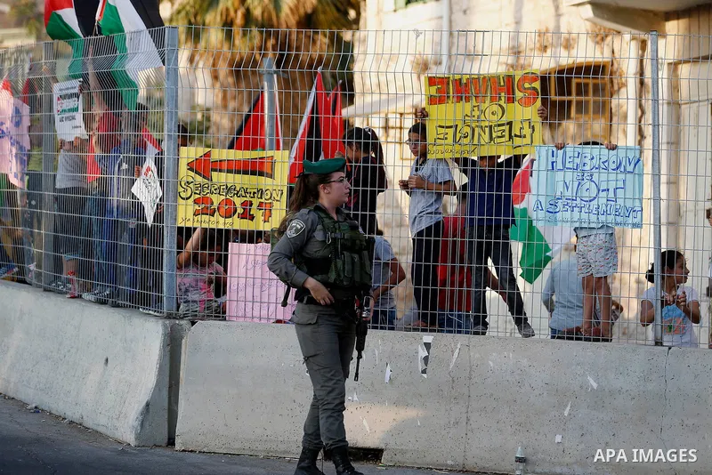 A female Israeli soldier stands guard during a demonstration by Palestinian protesters in the West Bank city of Hebron on September 18, 2017. Israel has given Jewish settlement enclaves in the occupied West Bank city of...